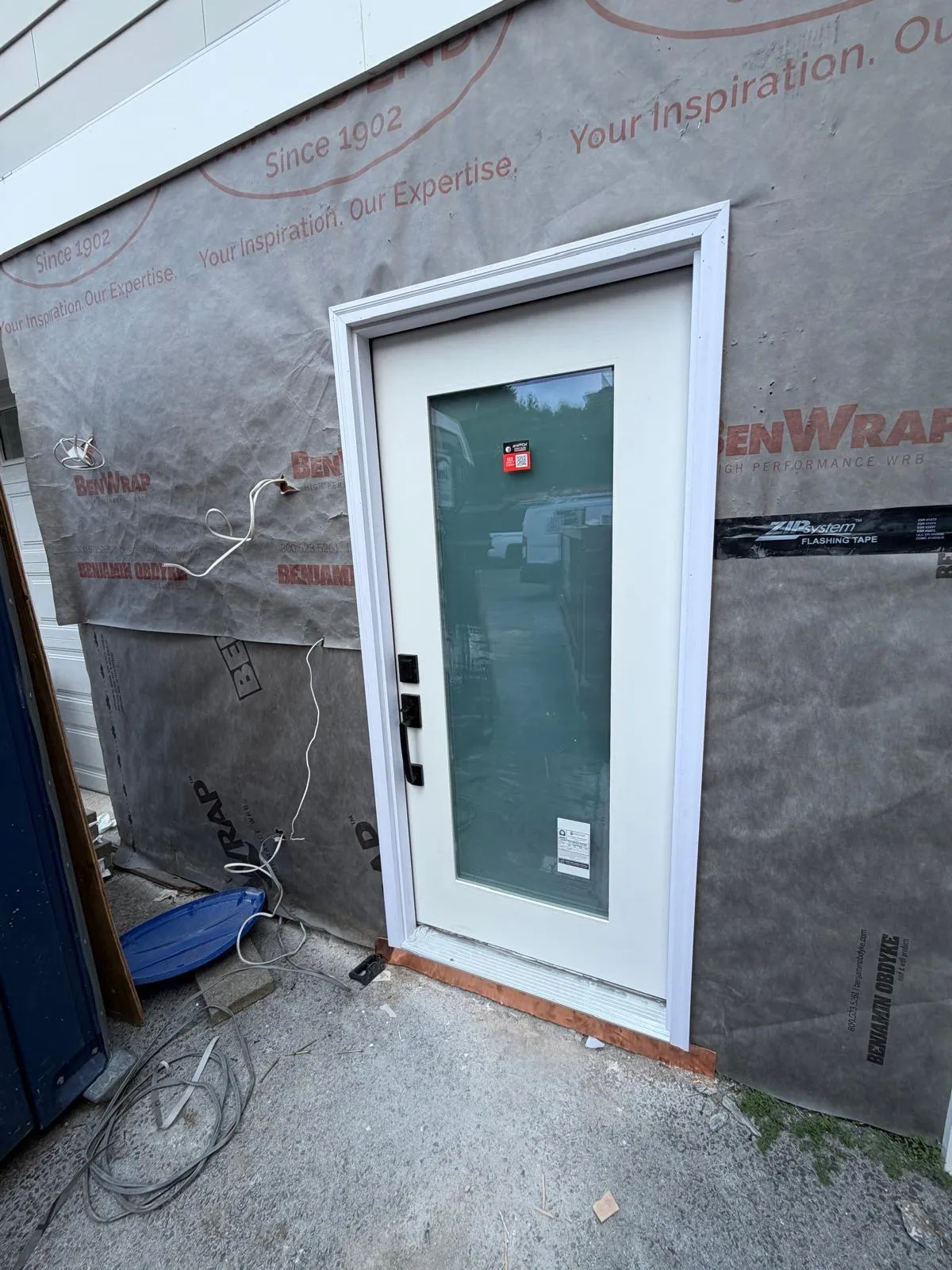 New glass door on a home with house wrap, installed by Mosquera Construction in Connecticut