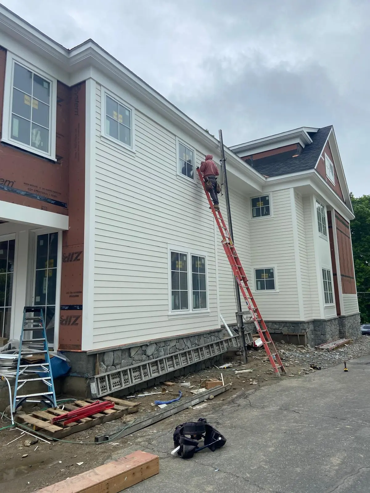 Siding installation from a ladder by Mosquera Construction in Connecticut