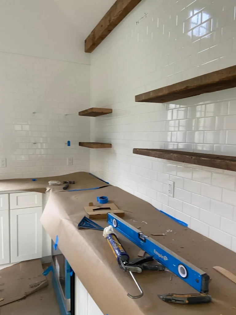 Kitchen with floating shelves and subway tile by Mosquera Construction in Connecticut