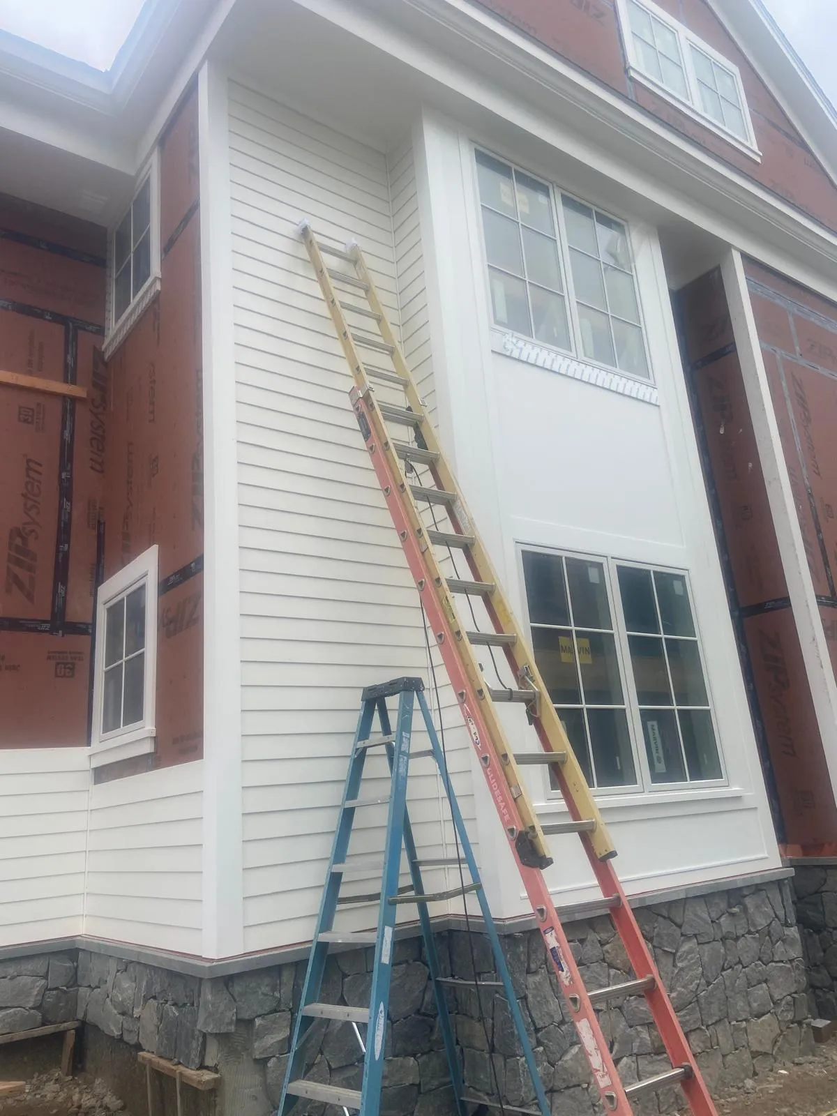 Siding and brick facade during work by Mosquera Construction in Connecticut