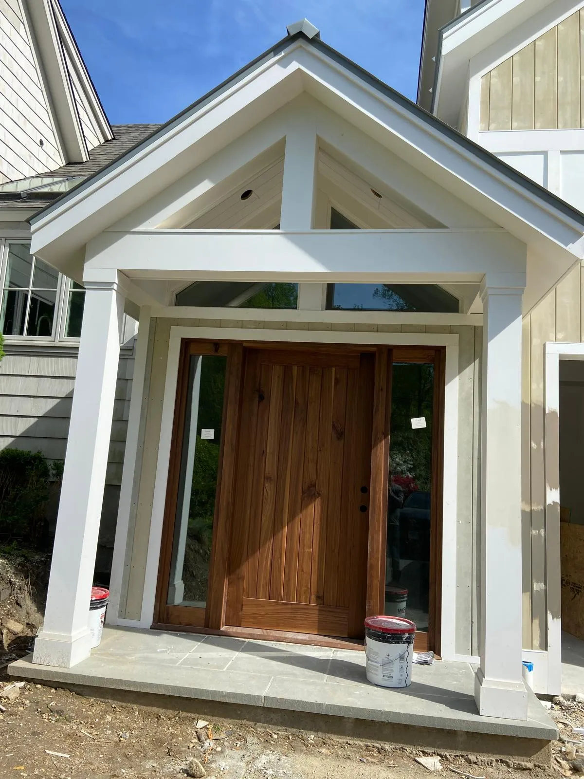 Entry portico with a wood door by Mosquera Construction in Connecticut