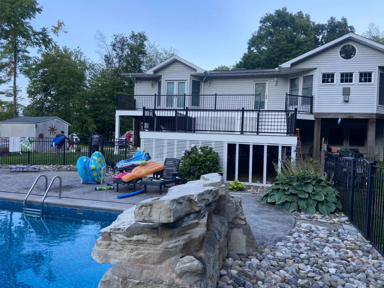 Deck with black railings by a pool, built by Mosquera Construction in Connecticut