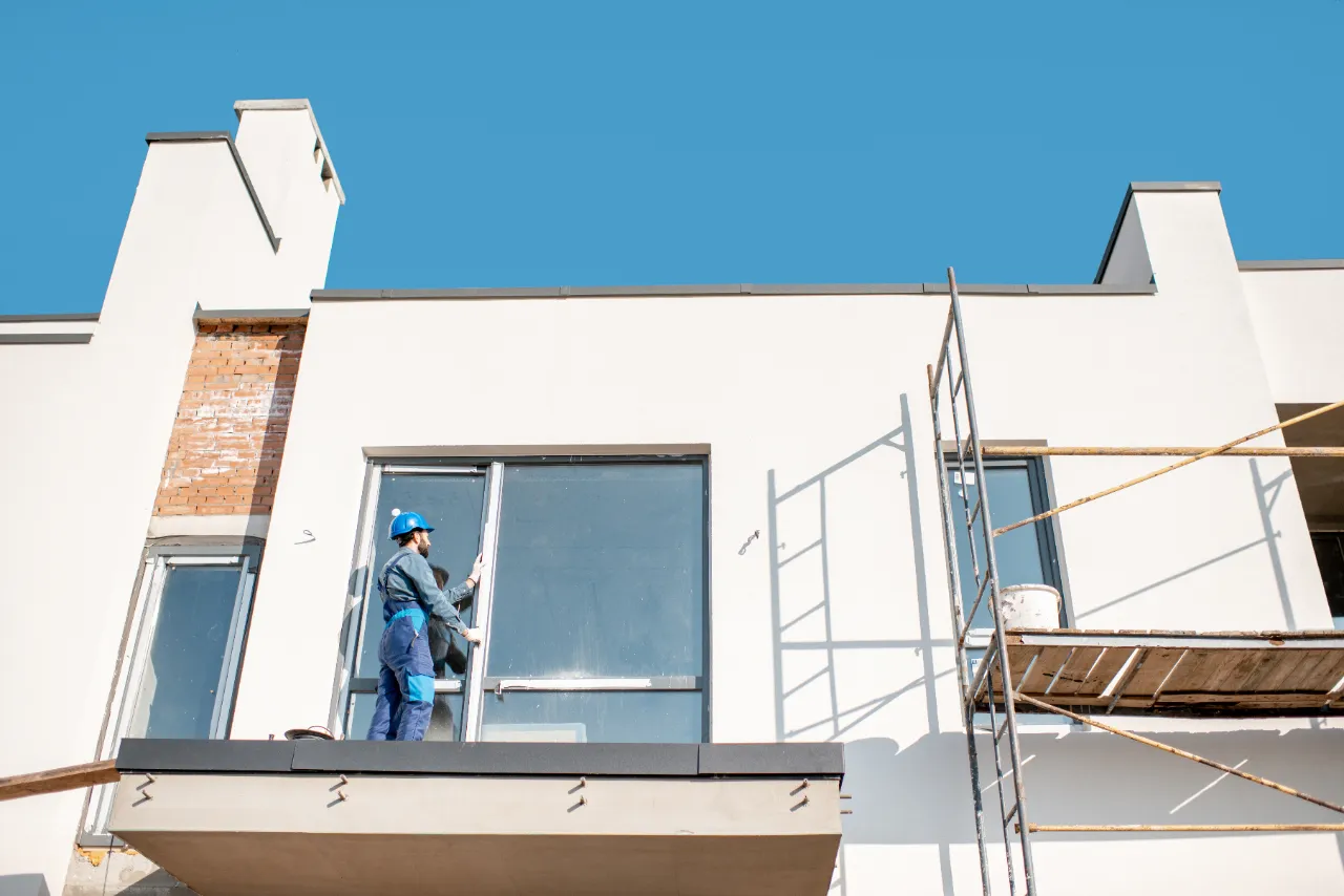 Worker installing a window on a home