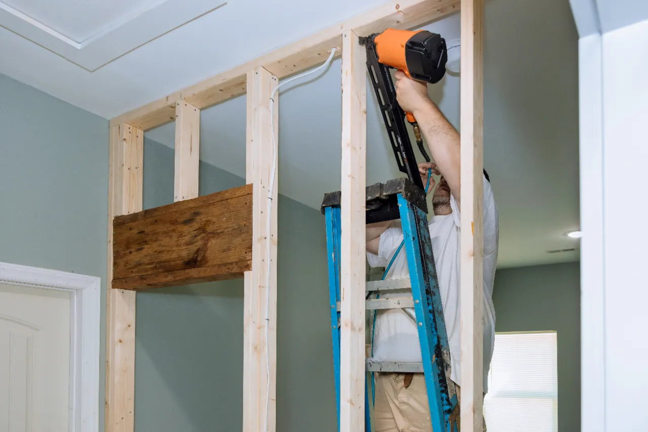 Contractor building a wall with a nail gun