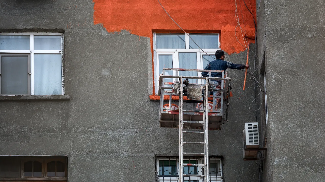 Painter on scaffolding painting a facade